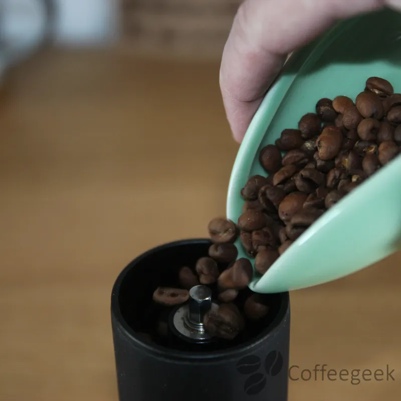 Los granos de café se vierten en el molinillo Exagrind