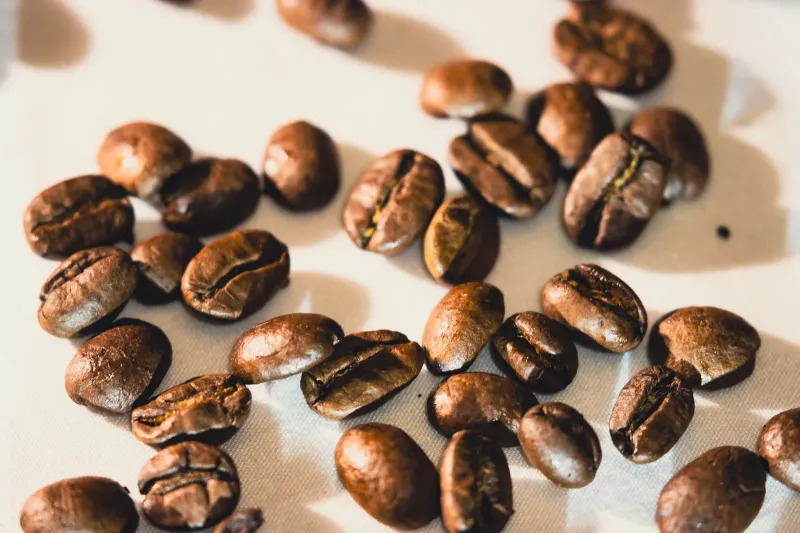Primer plano de granos de café en proceso de tostación, superficie ligeramente agrietada