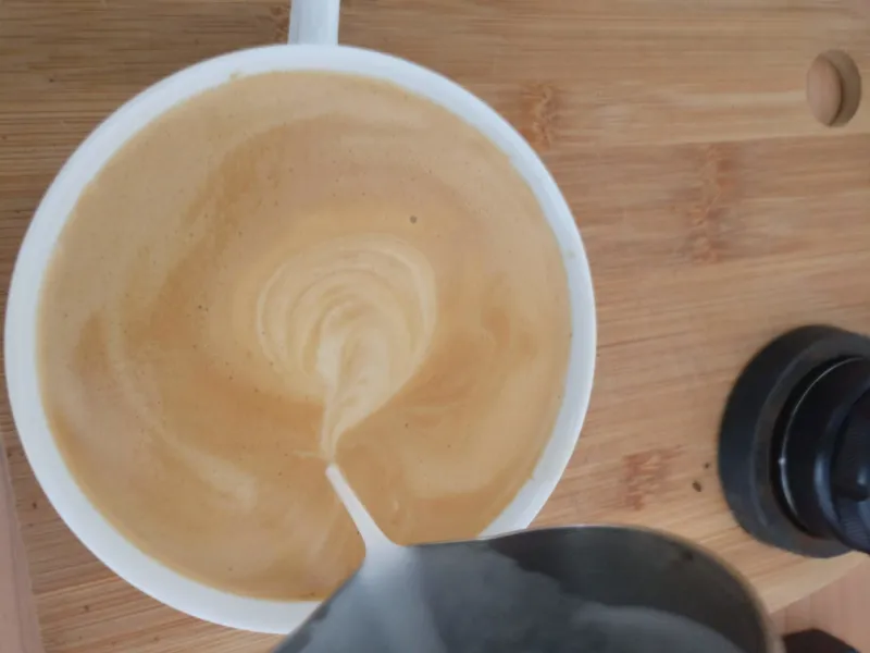 The frothed milk is poured like a latte into the espresso