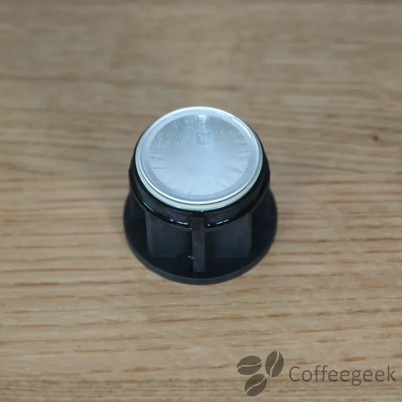 Pierce the head of the Nespresso capsule by inserting it into the capsule holder.