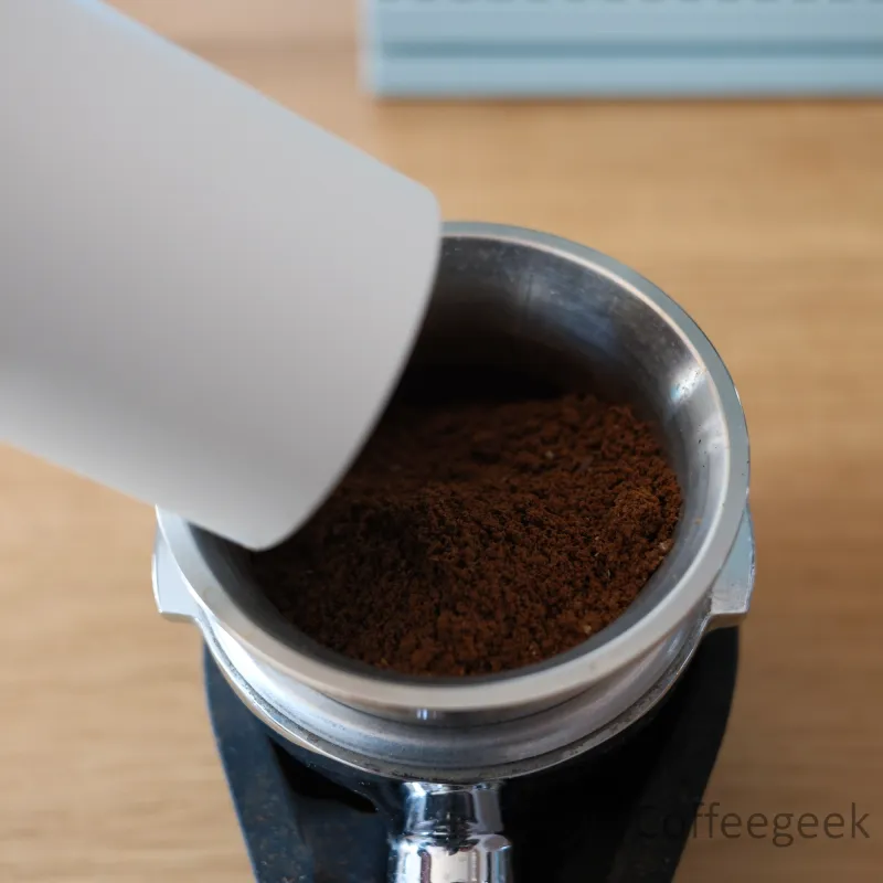 Transferring grounds from the Timemore Bricks 01S cup into an espresso portafilter