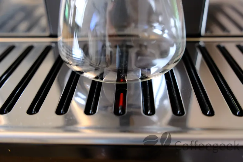 Primo piano della griglia poggiatazze della De'Longhi PrimaDonna Aromatic, con piccoli elementi in plastica in rilievo che proteggono la superficie lucida