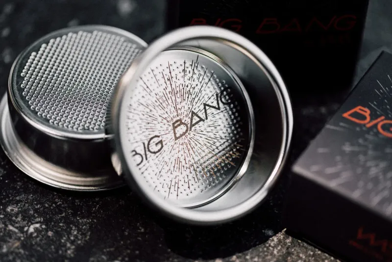 Deux filtres Big Bang, dont l'un montre la gravure en étoile de son fond perforé, avec la boîte derrière