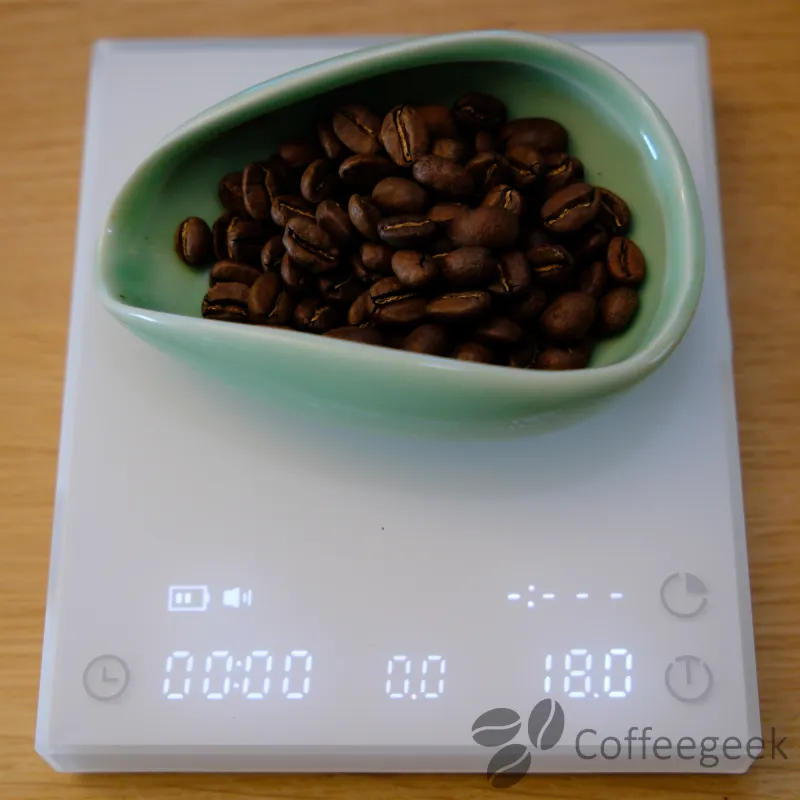 Pesatura di 18g di caffè Pink Betania sulla bilancia Timemore Basic 3