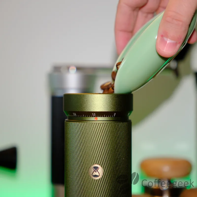 Chicchi di caffè versati nella tramoggia del Timemore S5 Pro per una macinatura da espresso