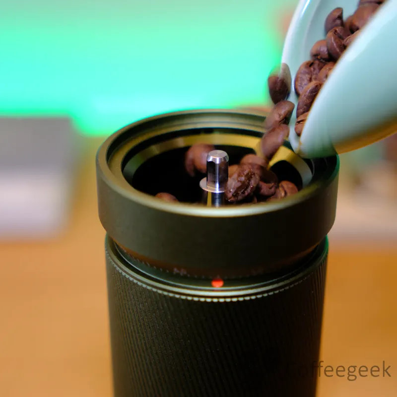 Chicchi di caffè versati nella tramoggia del Timemore S5 Pro